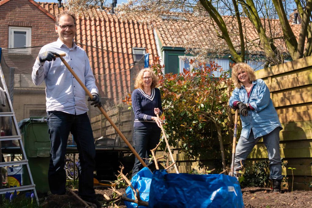 Vrijwilligers voor Stichting Present doen tuinwerk