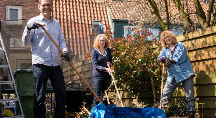 Vrijwilligers voor Stichting Present doen tuinwerk